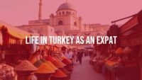 Expat life in Turkey, vibrant bazaar scene with colorful spices and textiles, historic architecture in background, warm sunlight, realistic.